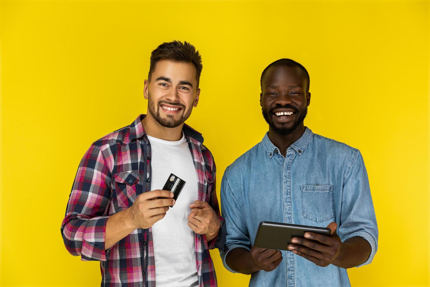 dois amigos usando cartão e tablet foto