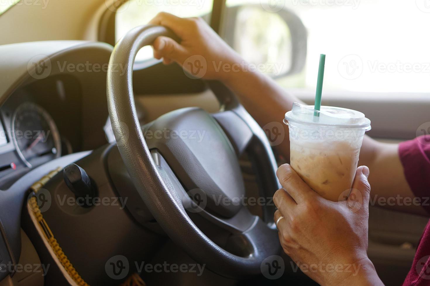 closeup mão segura a xícara de café gelado para beber no carro. conceito, baverge para refrescar ou ajudar a acordar do sono durante a condução que pode causar acidentes de carro. foto