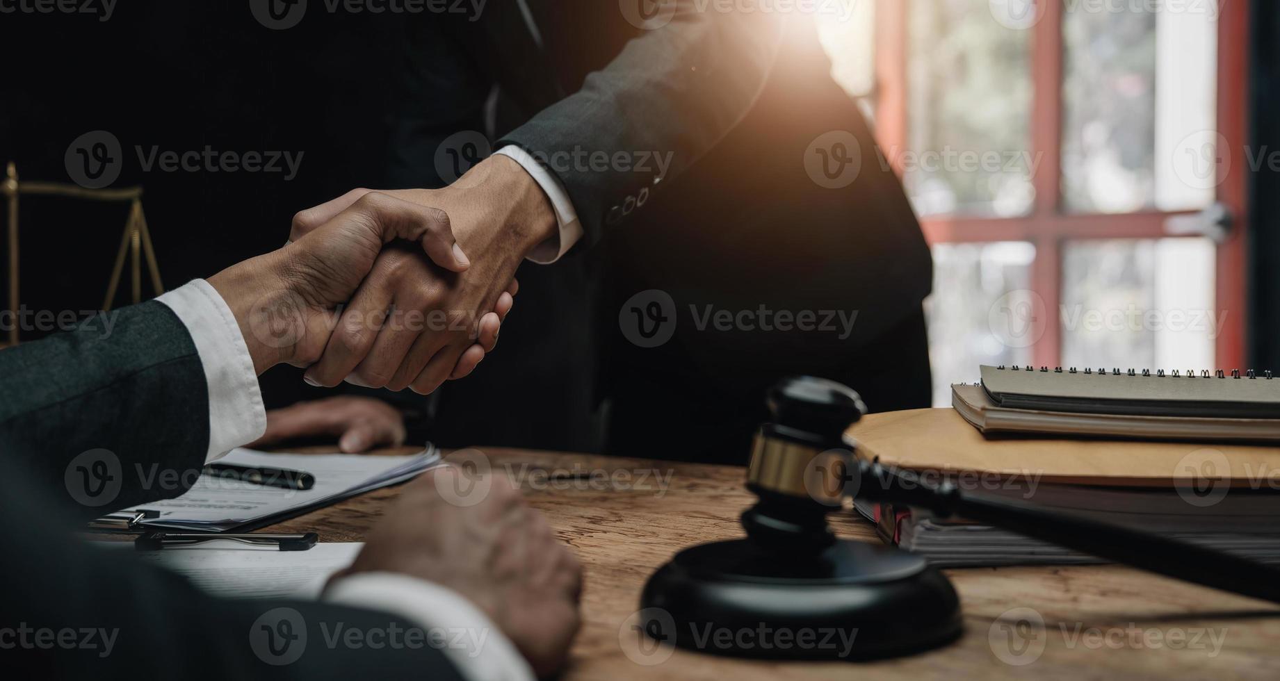 empresário apertando as mãos para selar um acordo com seus advogados parceiros ou advogados discutindo um acordo contratual. foto