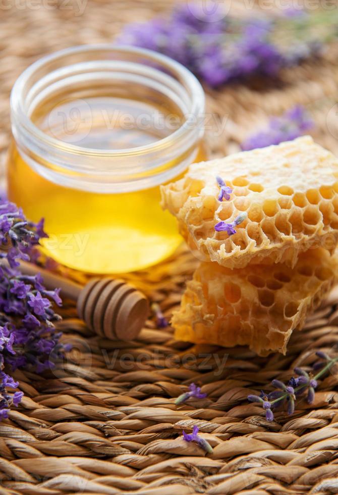 jarra com mel e flores frescas de lavanda foto