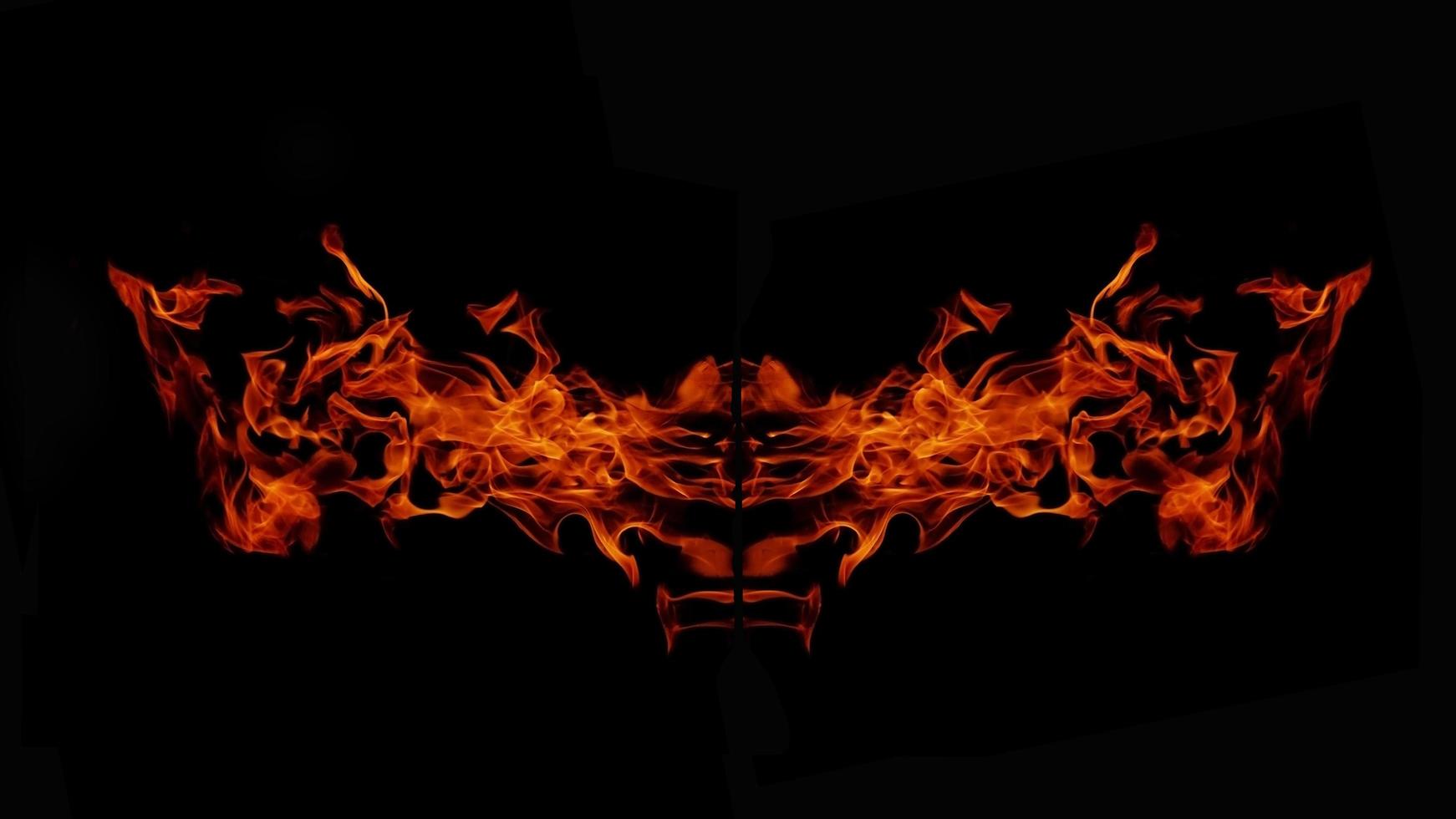 uma bela chama em forma como imaginada. como do inferno, mostrando um fervor perigoso e ardente, fundo preto foto