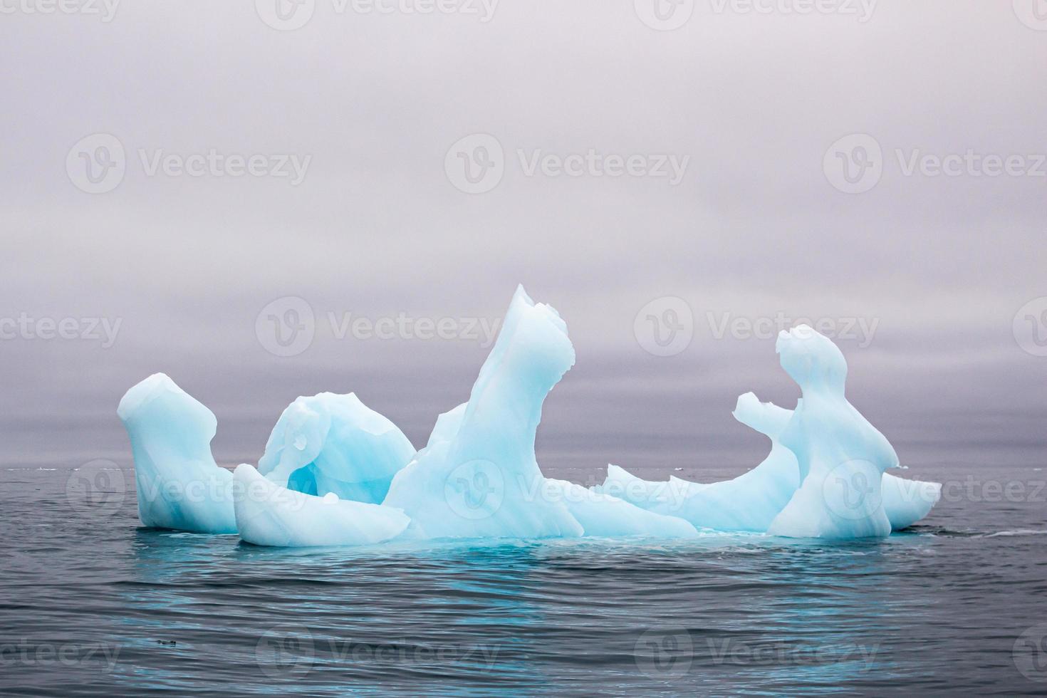 um iceberg azul flutuando no mar em svalberg foto