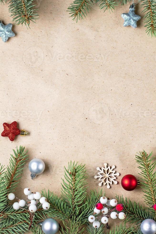borda do galho de árvore do abeto com decoração prateada e vermelha em papel ofício para cartão de natal com espaço de cópia para o texto. foto
