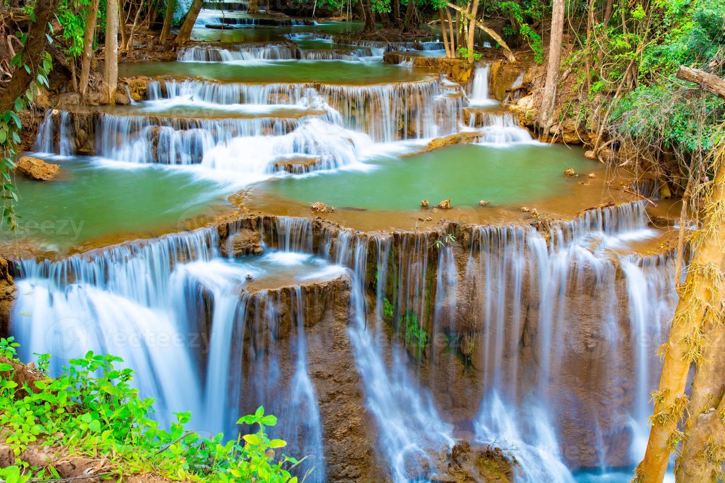 incrível cachoeira colorida na floresta do parque nacional durante a primavera, bela floresta profunda na tailândia, longa exposição técnica, durante as férias e relaxar. foto