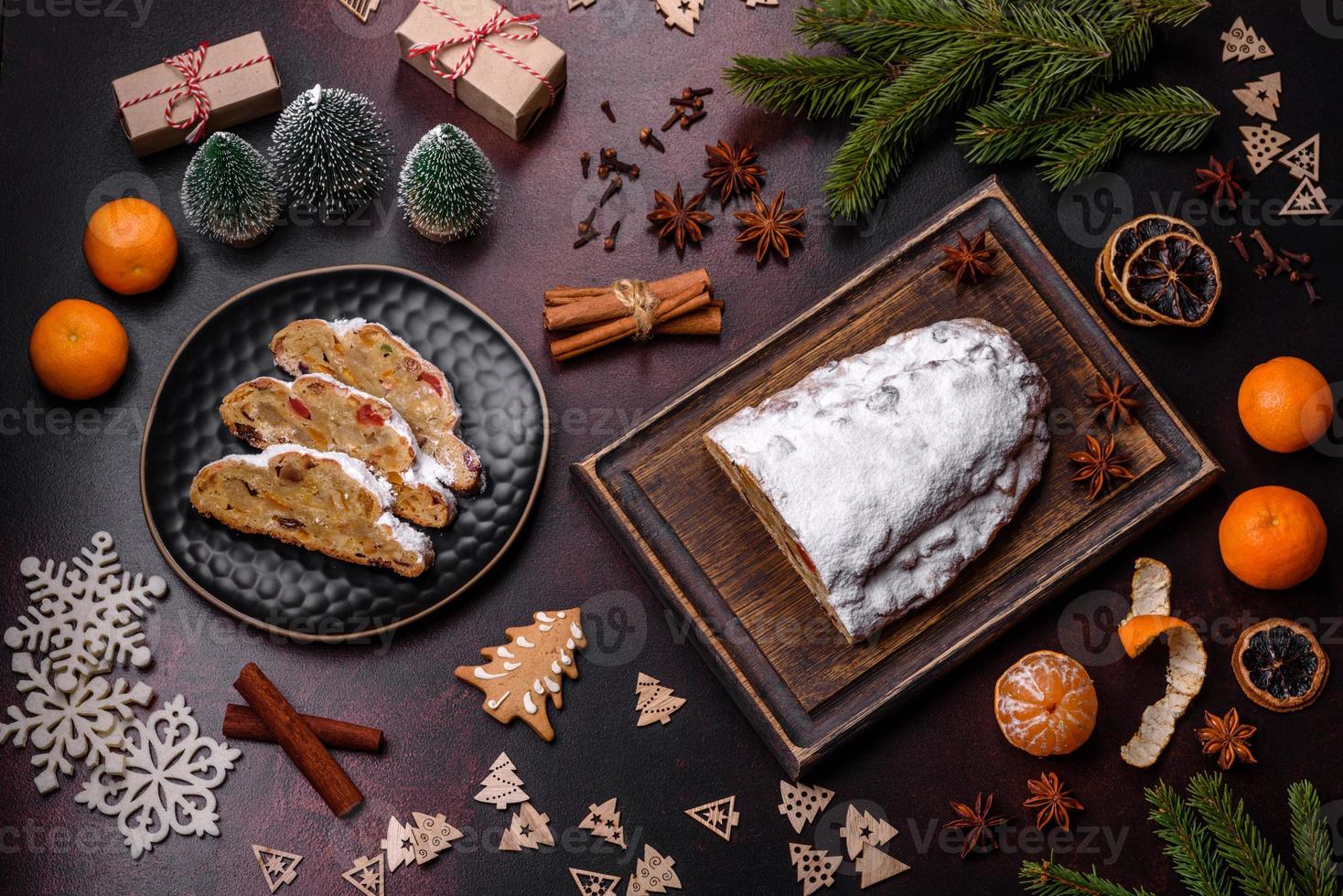 Stollen de torta de natal com maçapão, frutas e nozes em um fundo escuro de concreto foto