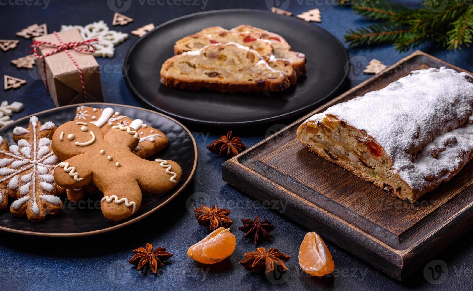 deliciosa torta festiva de ano novo com frutas cristalizadas, maçapão e nozes em um fundo escuro de concreto foto