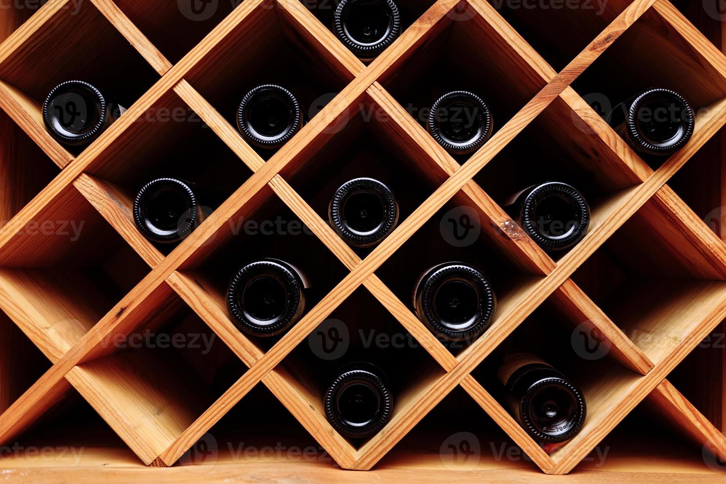 garrafas de vinho empilhadas em prateleiras de madeira. efeito vintage. foto