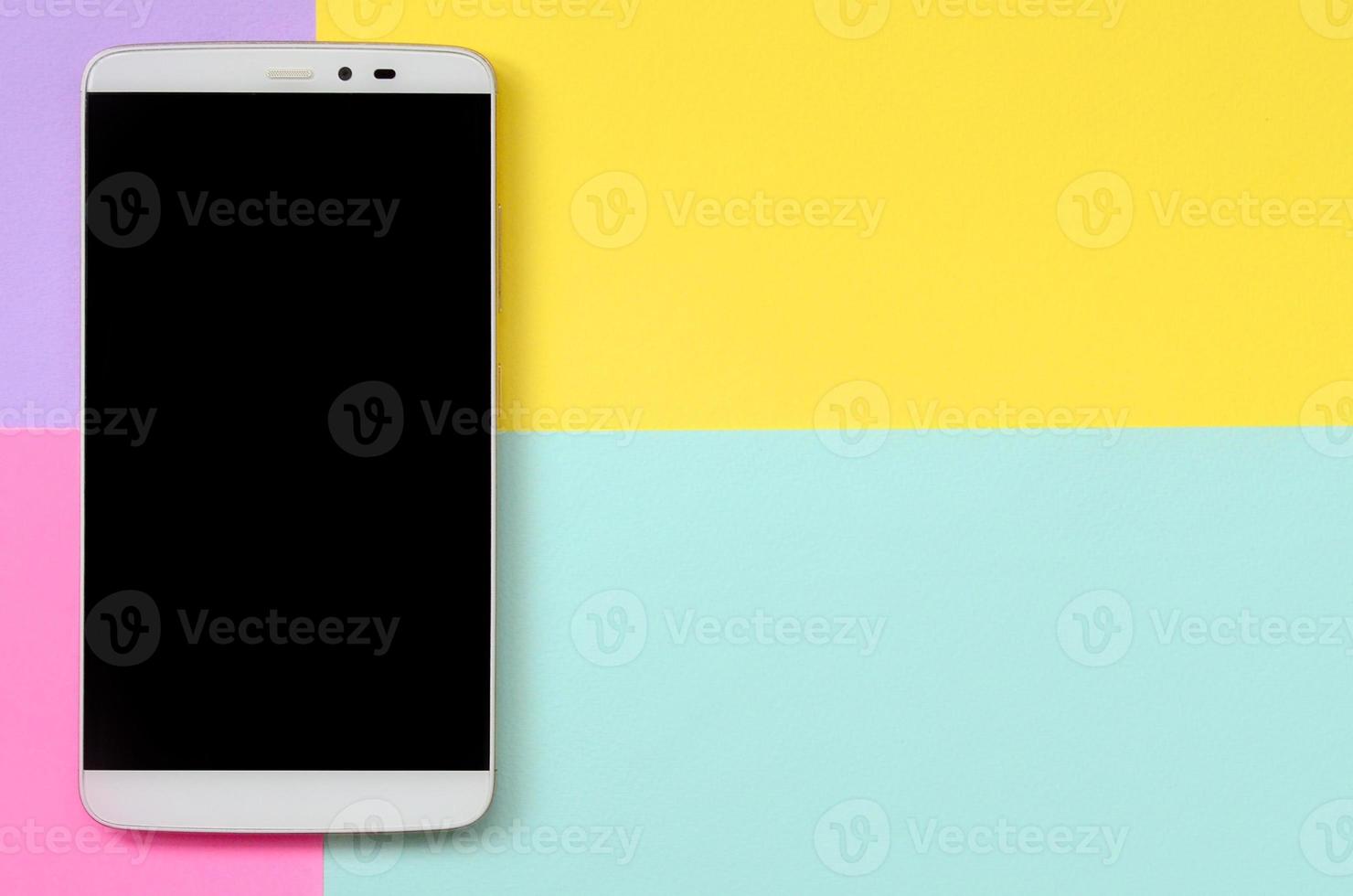 smartphone moderno com tela preta no fundo de textura de papel de cores pastel de moda azul, amarelo, violeta e rosa em conceito mínimo foto