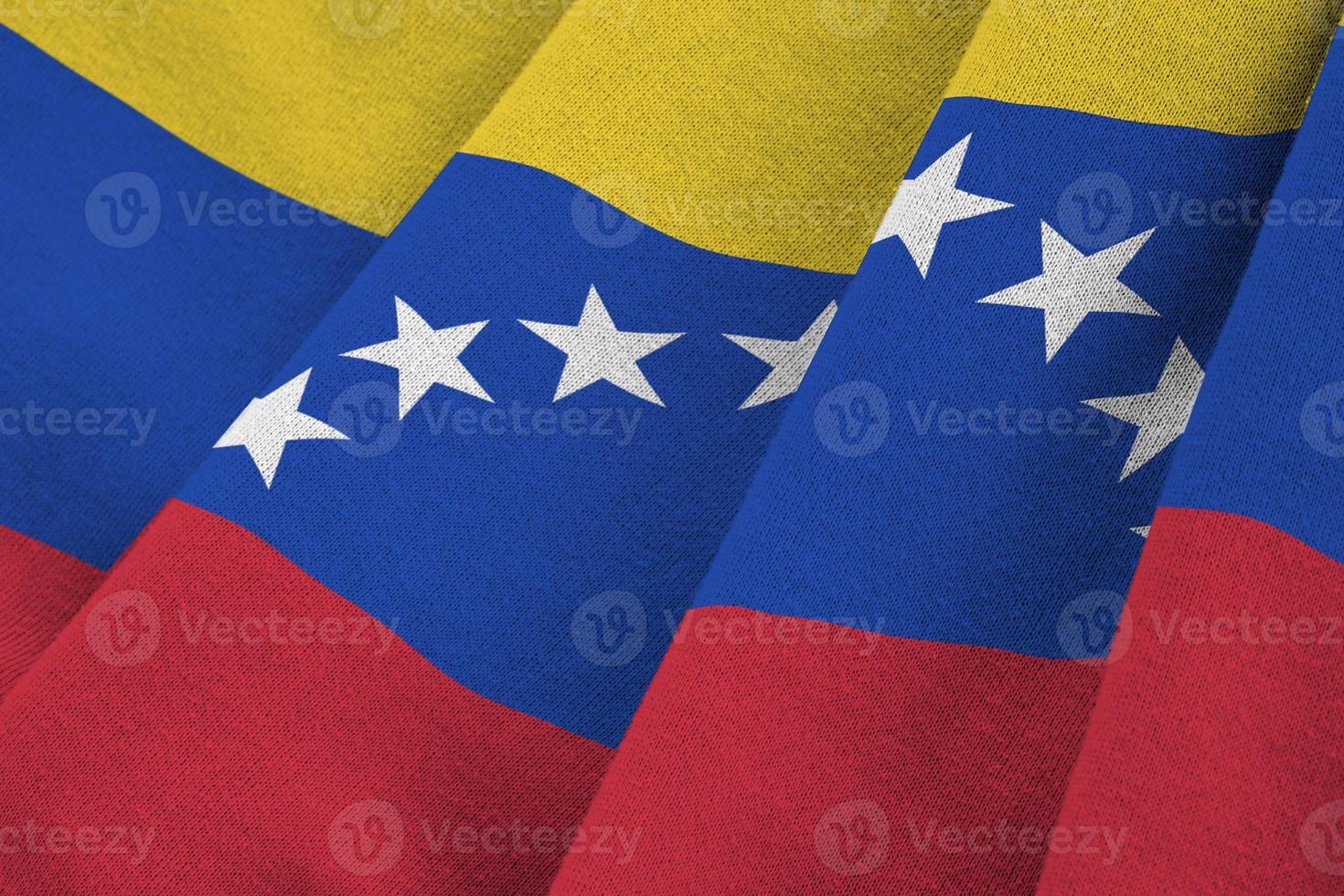 bandeira da venezuela com grandes dobras acenando de perto sob a luz do estúdio dentro de casa. os símbolos oficiais e cores no banner foto