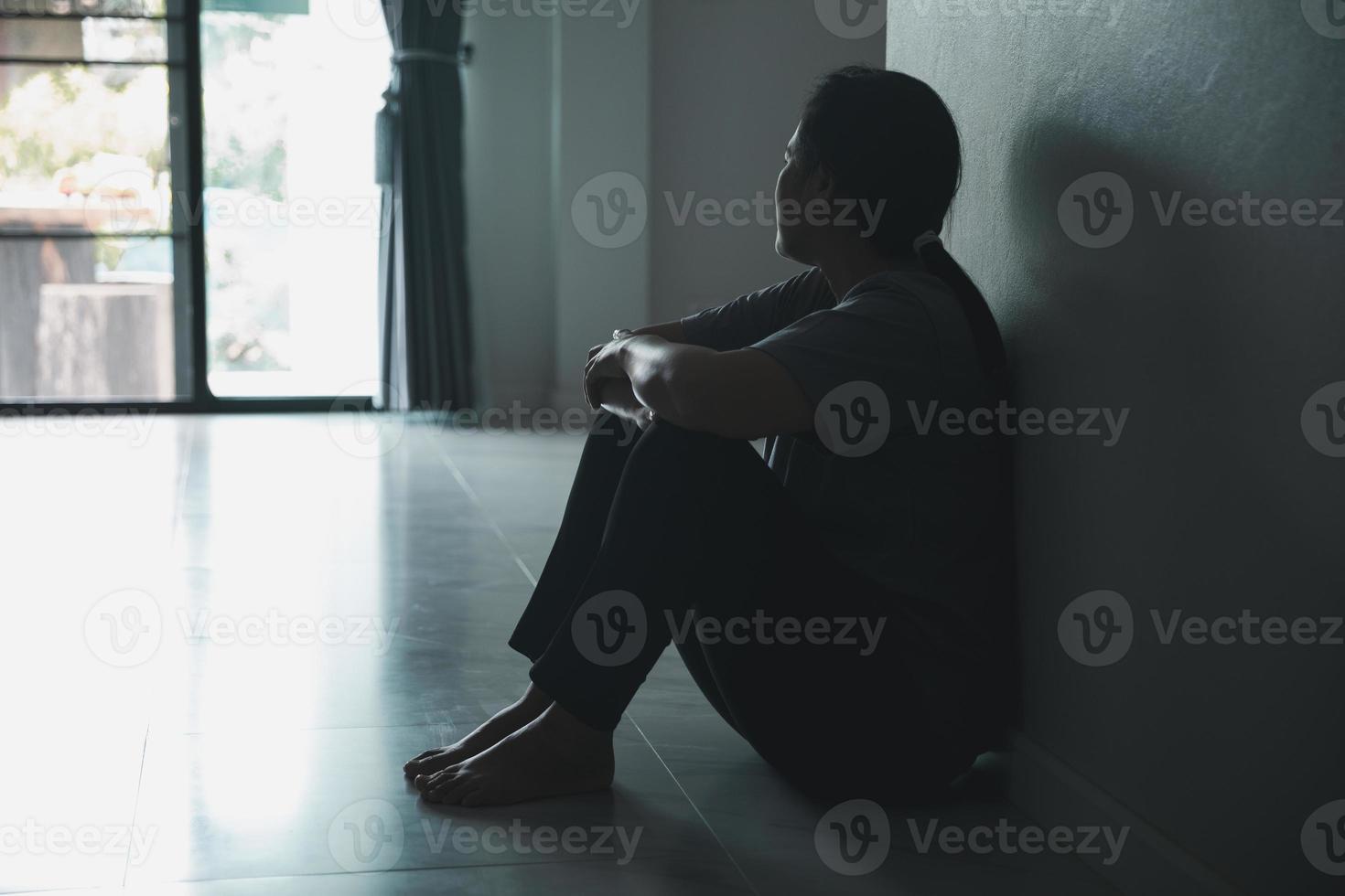 esquizofrenia com solitário e triste no conceito de depressão de saúde mental. mulher deprimida sentada contra a parede em casa com uma sombra na parede sentindo-se miserável. as mulheres estão deprimidas, medrosas e infelizes. foto