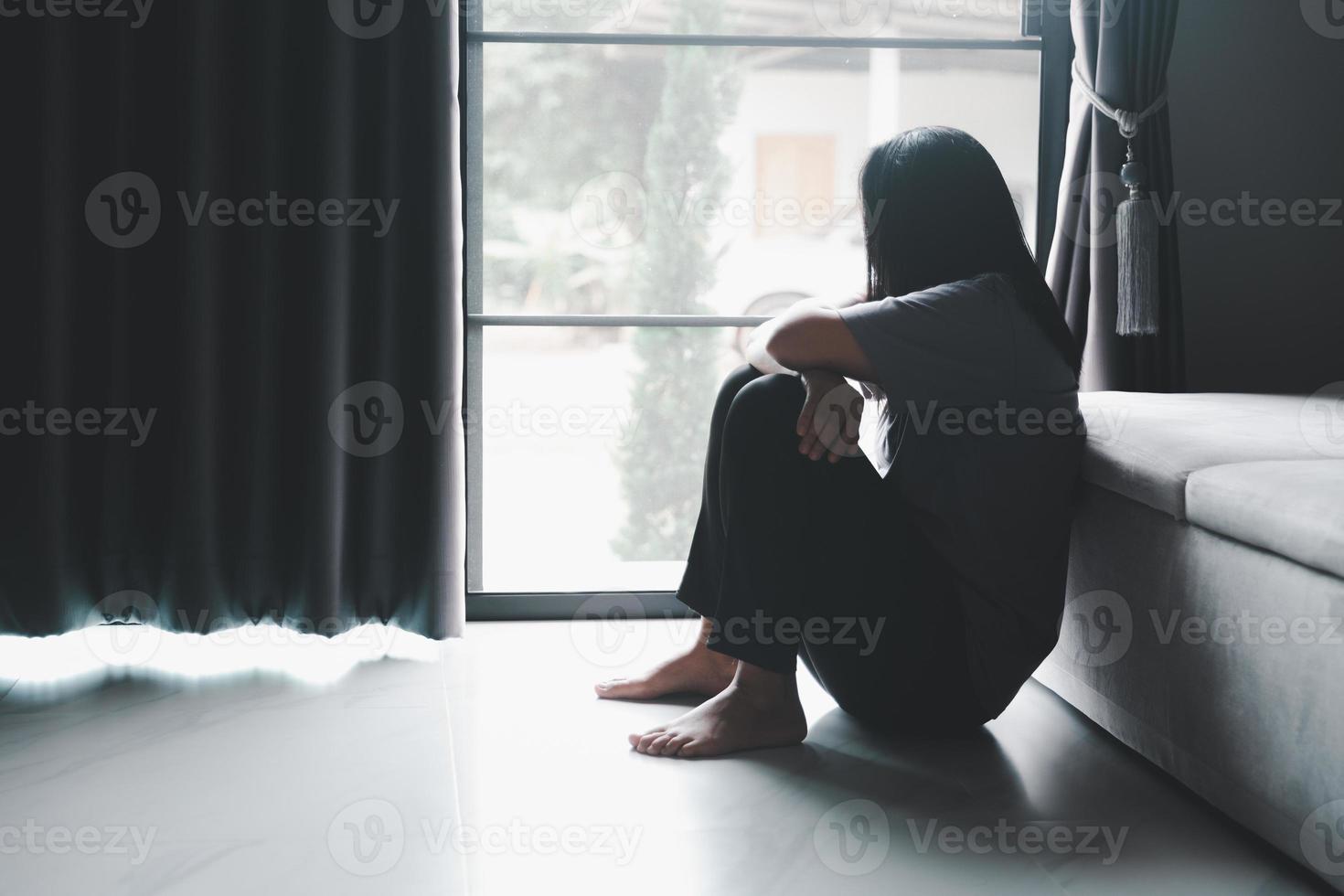 esquizofrenia com solitário e triste no conceito de depressão de saúde mental. mulher deprimida sentada contra o chão em casa com quarto escuro sentindo-se miserável. as mulheres estão deprimidas, medrosas e infelizes. foto