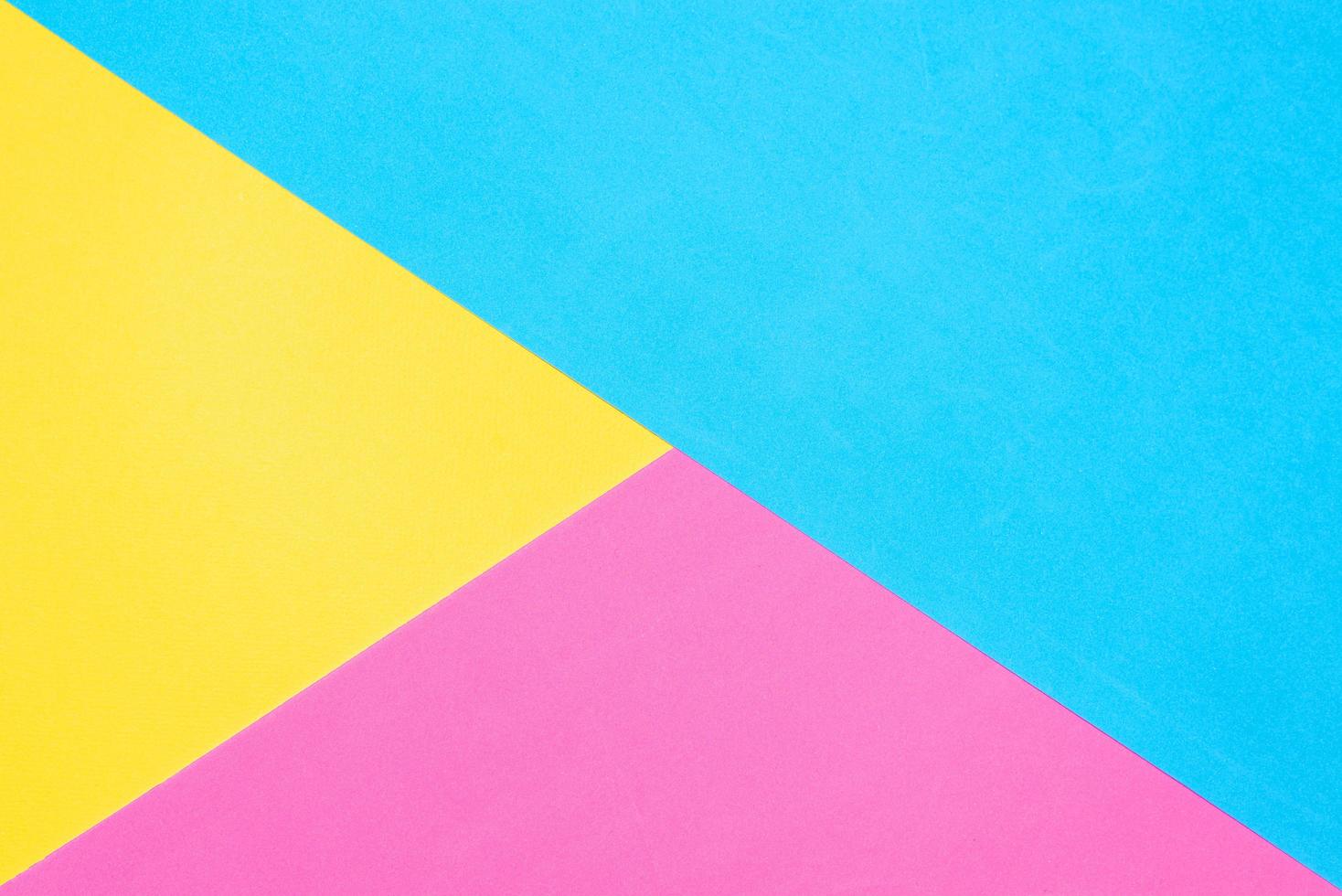 fundo de papel multicolorido. pano de fundo geométrico rosa e azul amarelo. diagonais e triângulos foto
