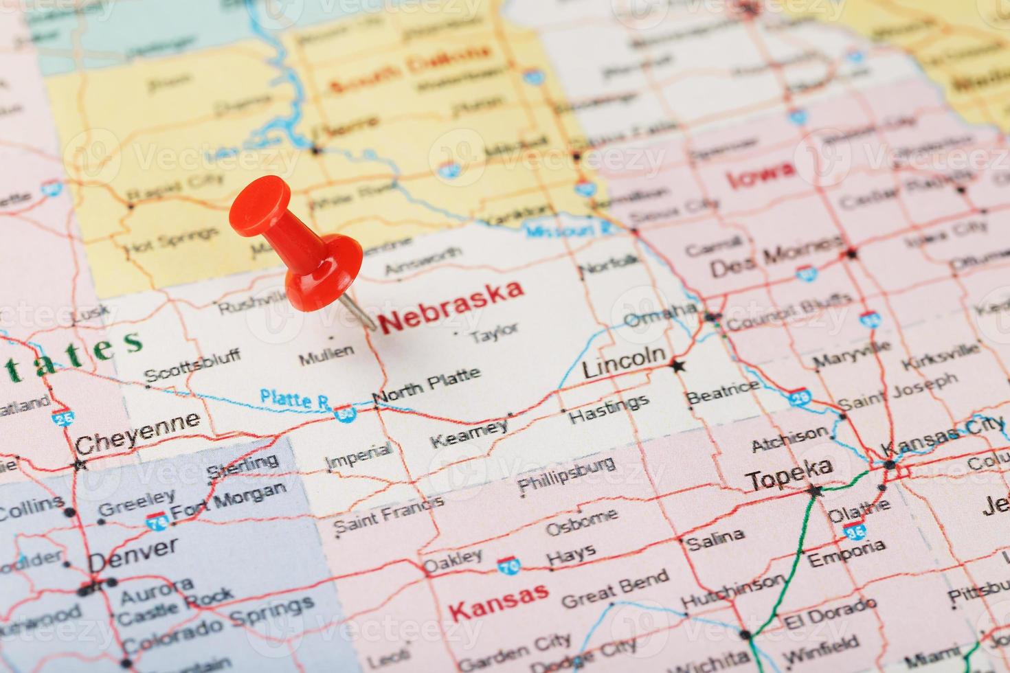 agulha clerical vermelha em um mapa dos eua, nebraska e a capital lincoln. fechar o mapa de nebraska com red tack foto