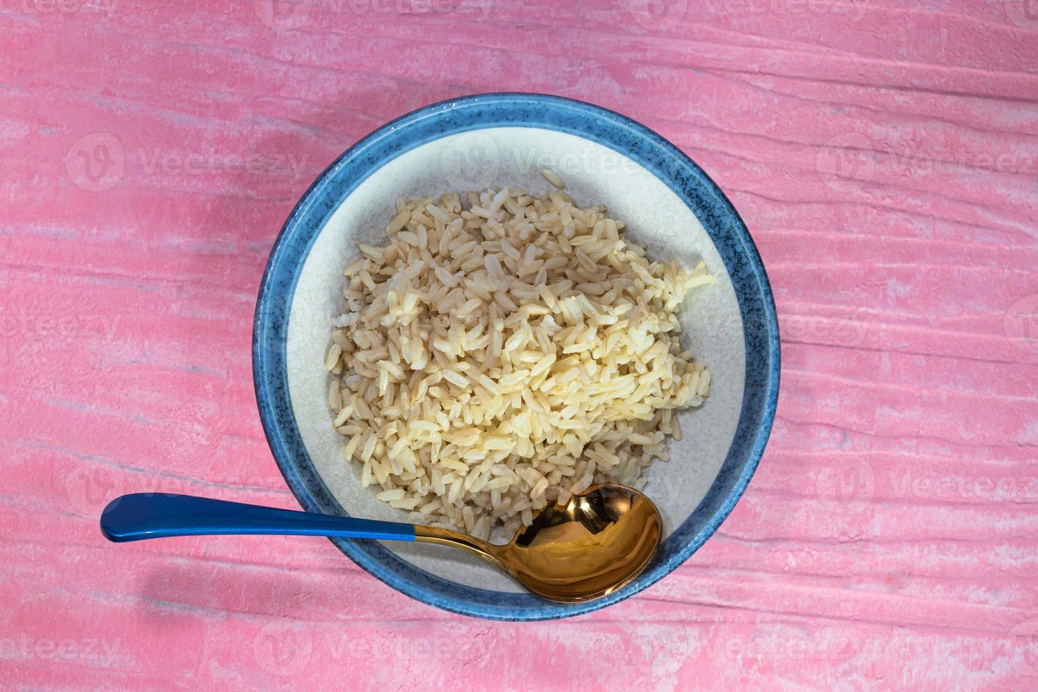 arroz marrom em tigela preta tem colher foto