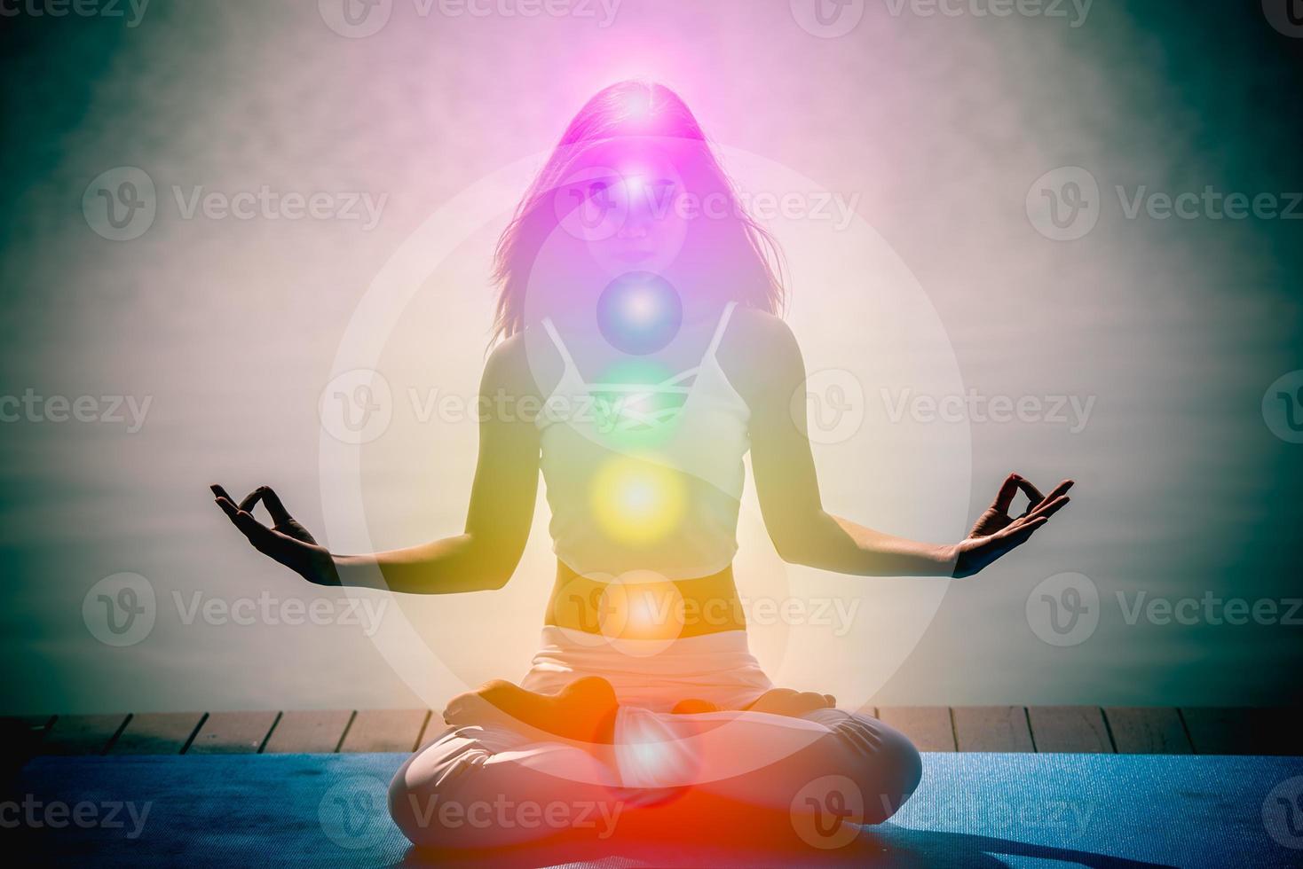 jovem mulher de aura em meditação de ioga com natureza sete chakras e símbolos yin yang. foto