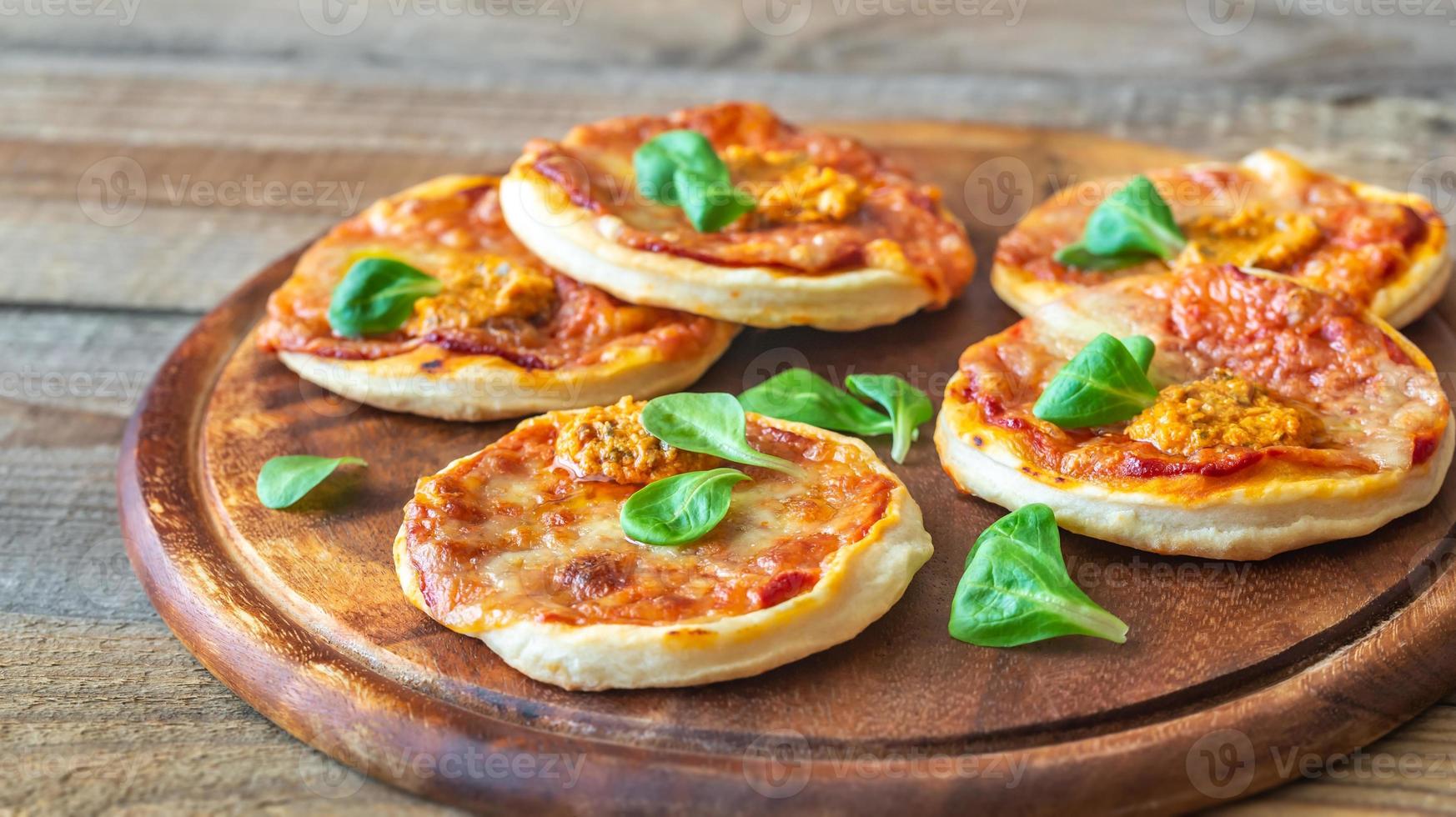 mini pizzas na tábua de madeira foto