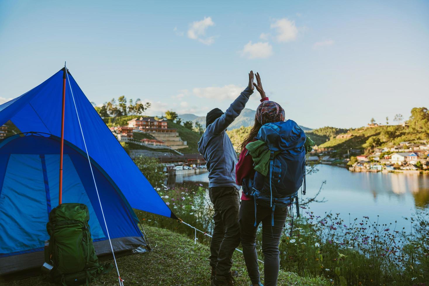 casal asiático acampamentos de montanha em vilas rurais, perto do lago, ideias de viagens, camping, férias relaxantes. foto