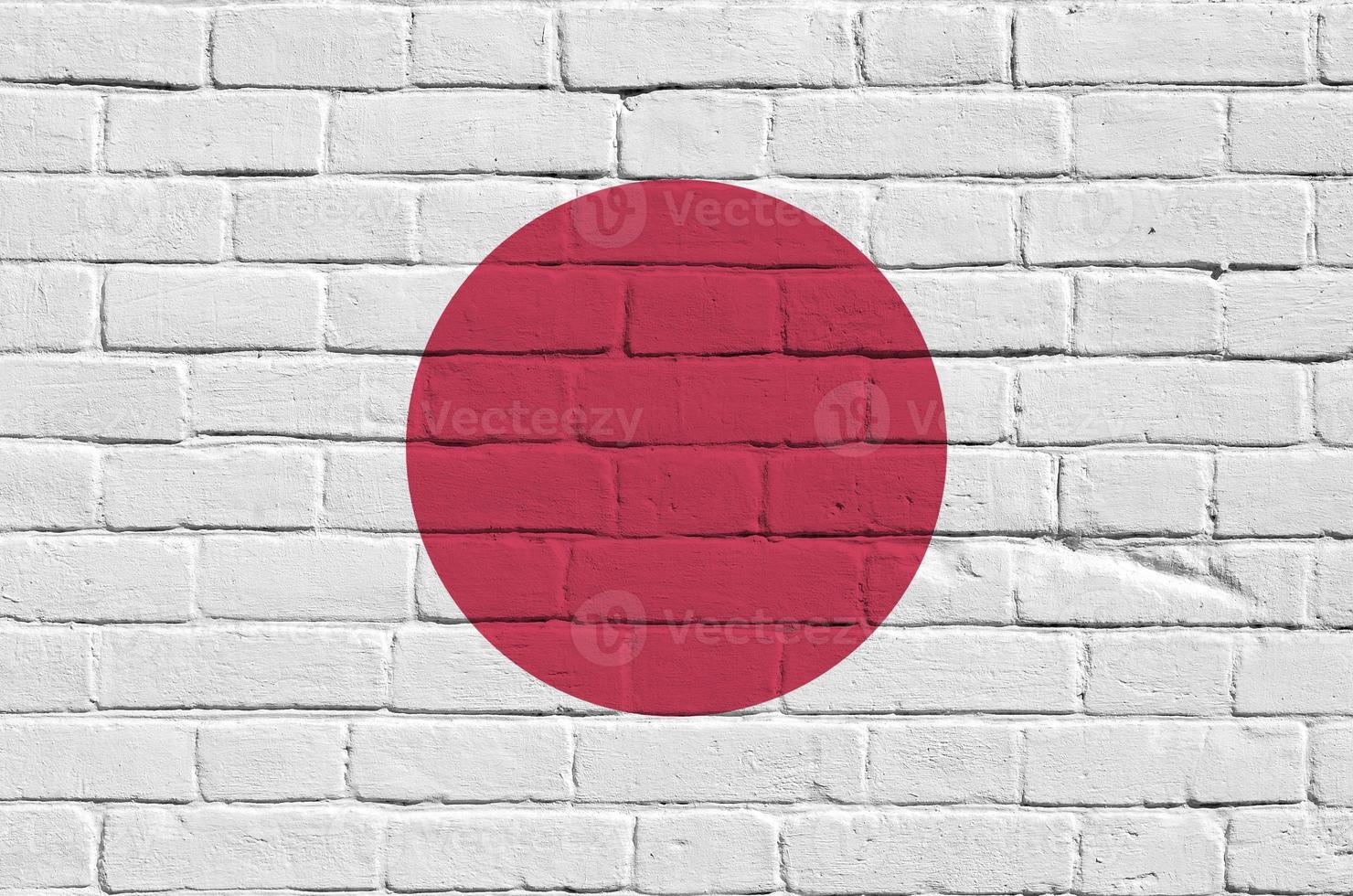 bandeira do japão retratada em cores de tinta na parede de tijolos antigos. banner texturizado em fundo de alvenaria de parede de tijolo grande foto