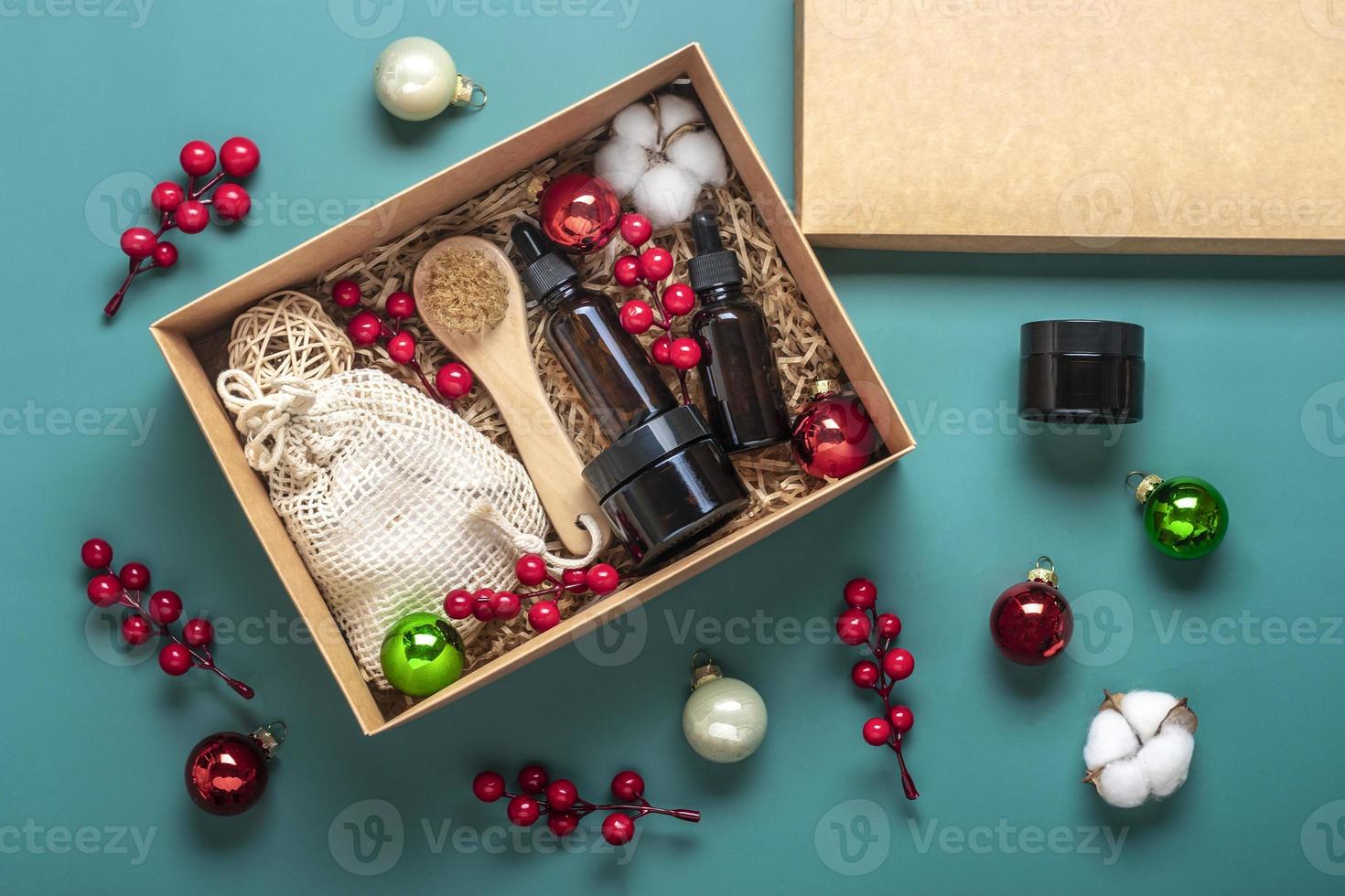 conjunto para frascos de óleo e creme de cosméticos ecológicos de caixa de cuidados, escova para lavar, almofadas de algodão em fundo verde presente para namorada, mãe para comemorar o conceito de natal vista superior flatlay foto