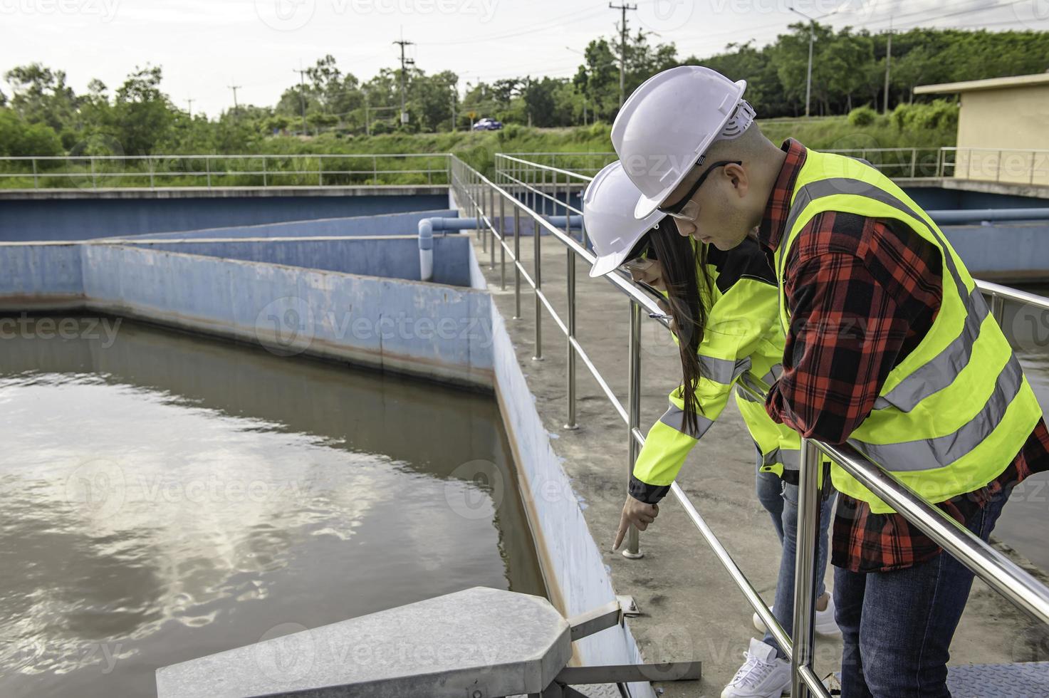 engenheiros ambientais trabalham em estações de tratamento de águas residuais, engenharia de abastecimento de água trabalhando em usinas de reciclagem de água para reutilização, técnicos e engenheiros discutem o trabalho em conjunto. foto