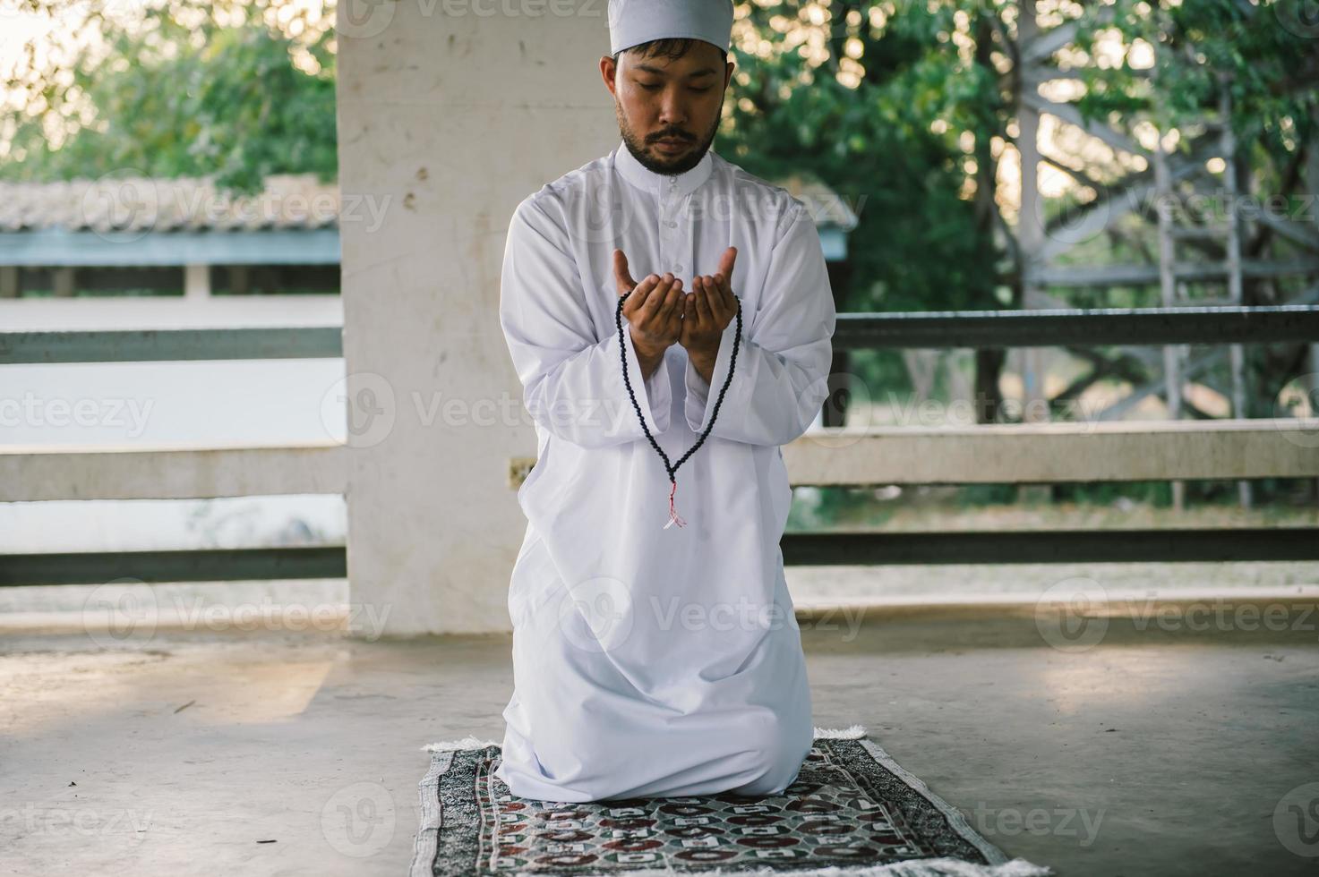 oração do homem islâmico asiático, jovem muçulmano rezando, conceito de festival do ramadã foto