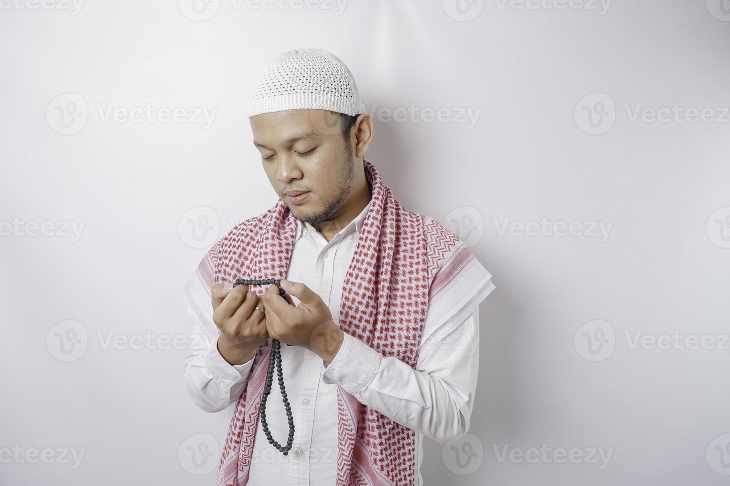 feliz homem muçulmano asiático bonito está orando a deus. foto