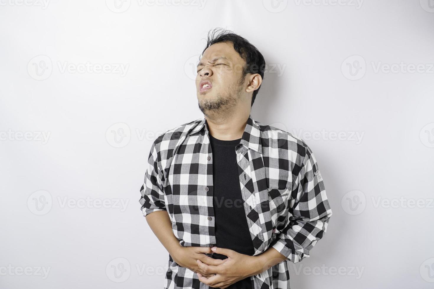 foto de jovem indisposto doente segurando a mão no estômago sofre dor isolada no fundo branco