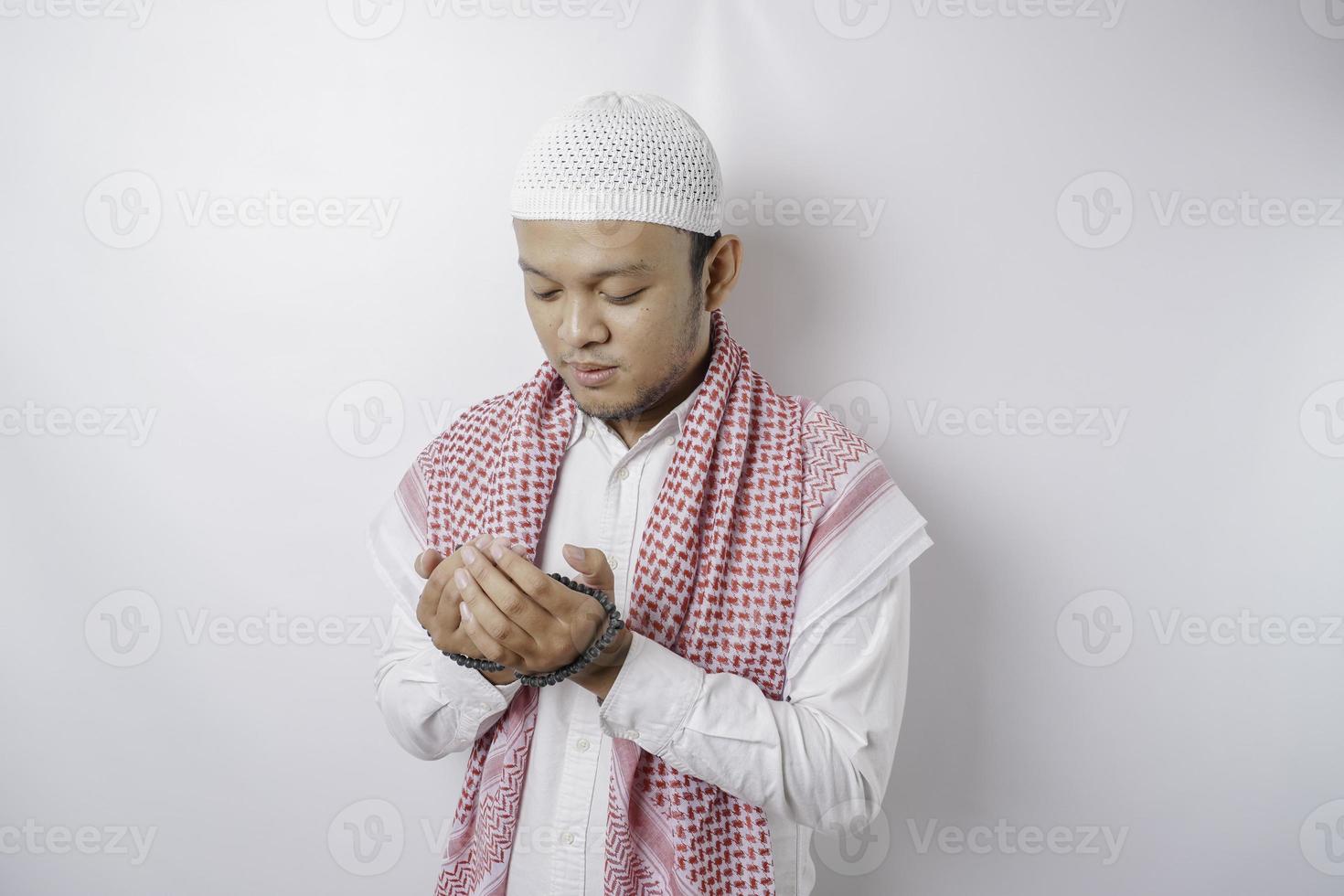 feliz homem muçulmano asiático bonito está orando a deus. foto