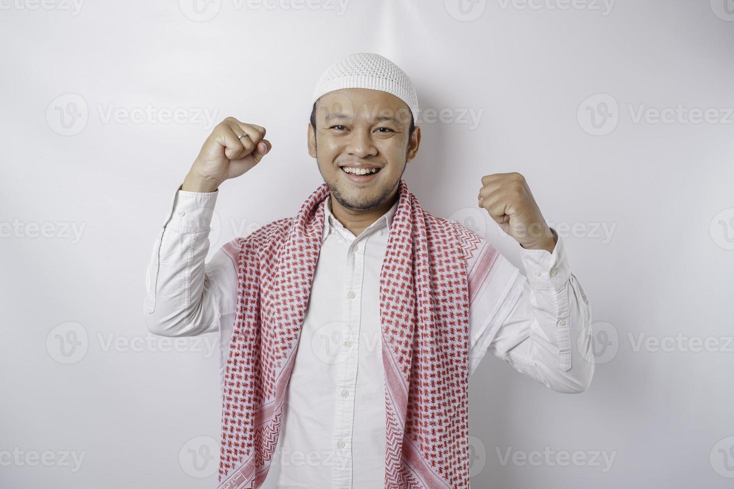 um jovem muçulmano asiático com uma expressão de sucesso feliz isolado pelo fundo branco foto