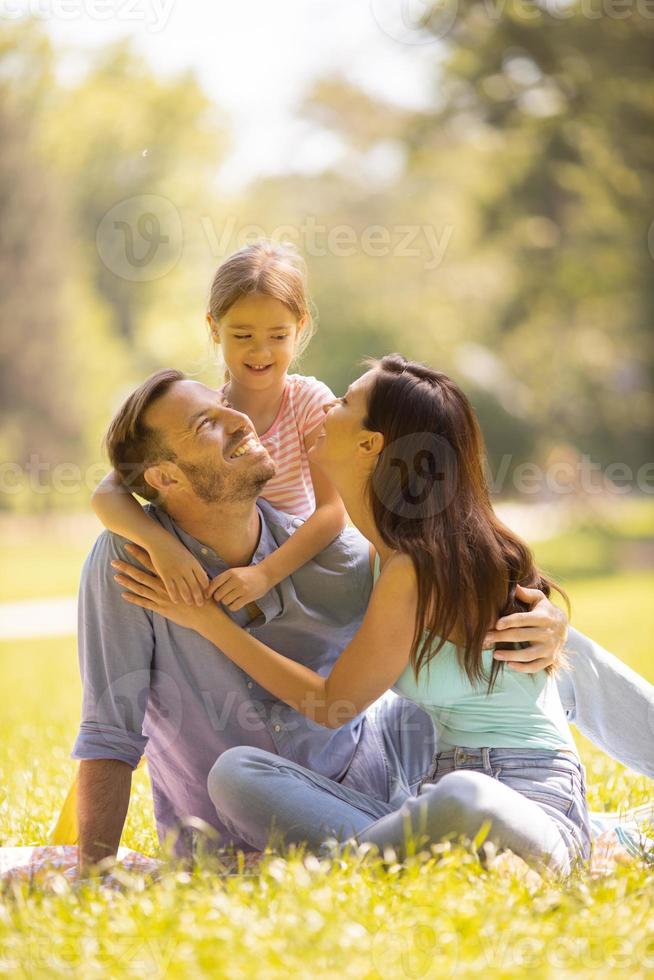 família jovem e feliz com a filhinha se divertindo no parque em um dia ensolarado foto