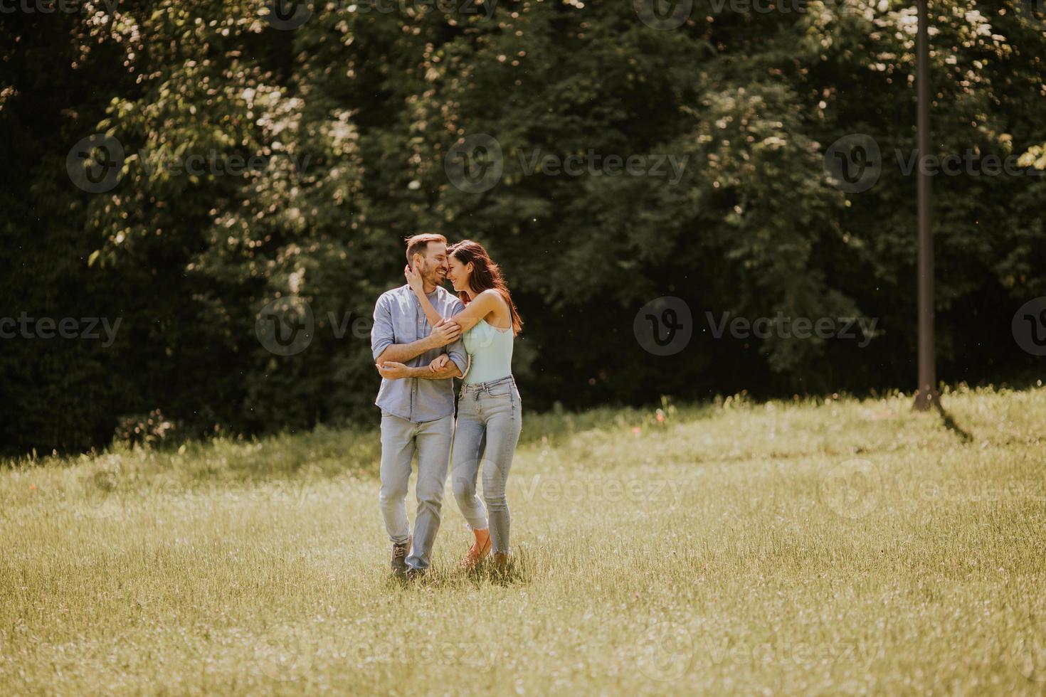 jovem casal apaixonado no campo de grama foto