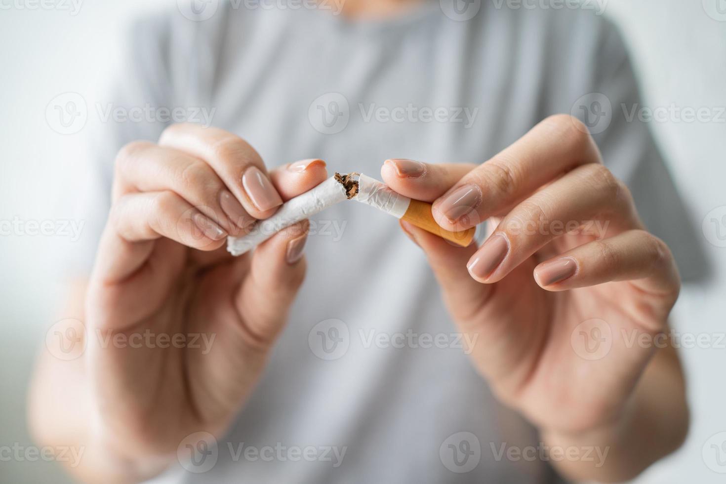 a mão do jovem quebra um close-up de cigarro. conceito de dano de fumar. dia mundial sem fumo. foto