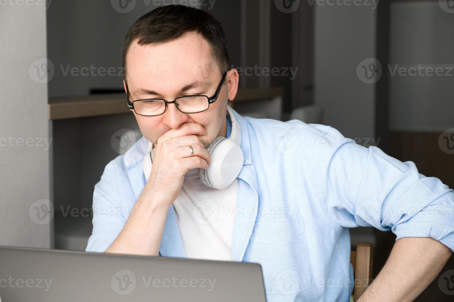 homem asiático pensando em alguma decisão ou problema, olhando para a tela do laptop. estressado demais. sob pressão. foto