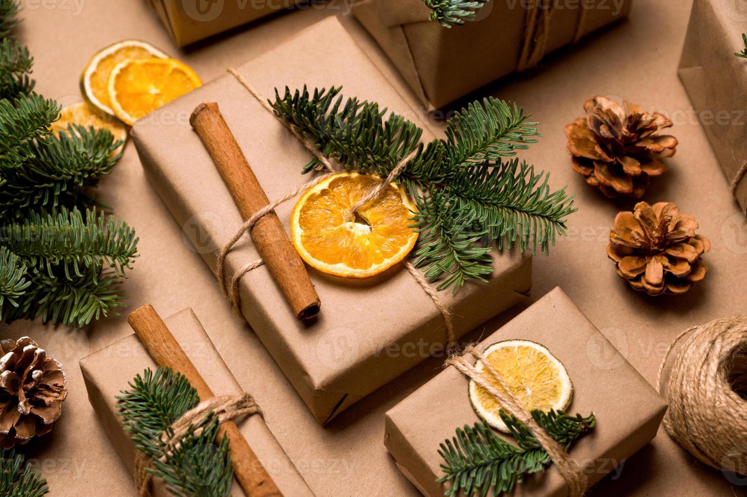 conceito de natal natureza morta com presentes em papel ofício decorado com materiais naturais. embrulhando presentes para feriados. foto