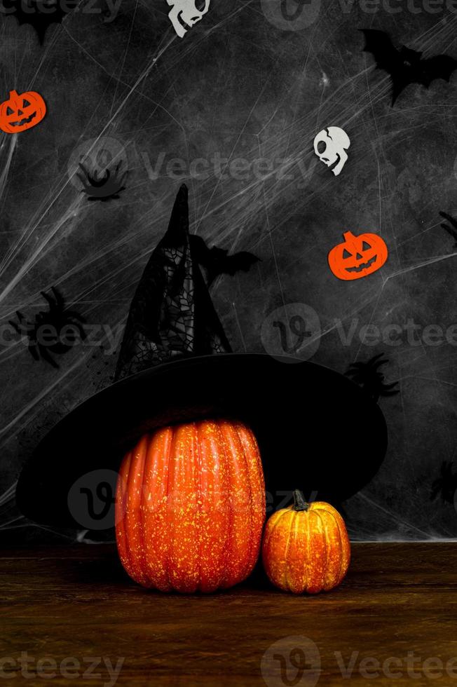 banner vertical de halloween com abóbora com chapéu de bruxa contra fundo escuro. banner nas cores balck e laranja. foto