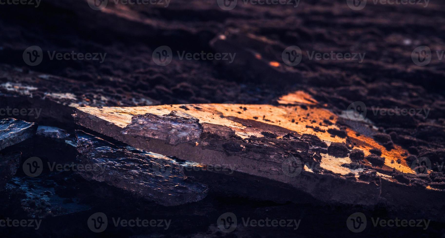 costa do mar báltico com seixos e gelo ao pôr do sol foto