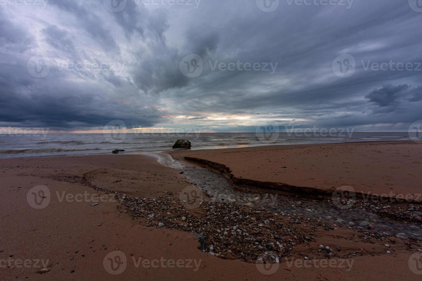 pedras na costa do mar báltico ao pôr do sol foto