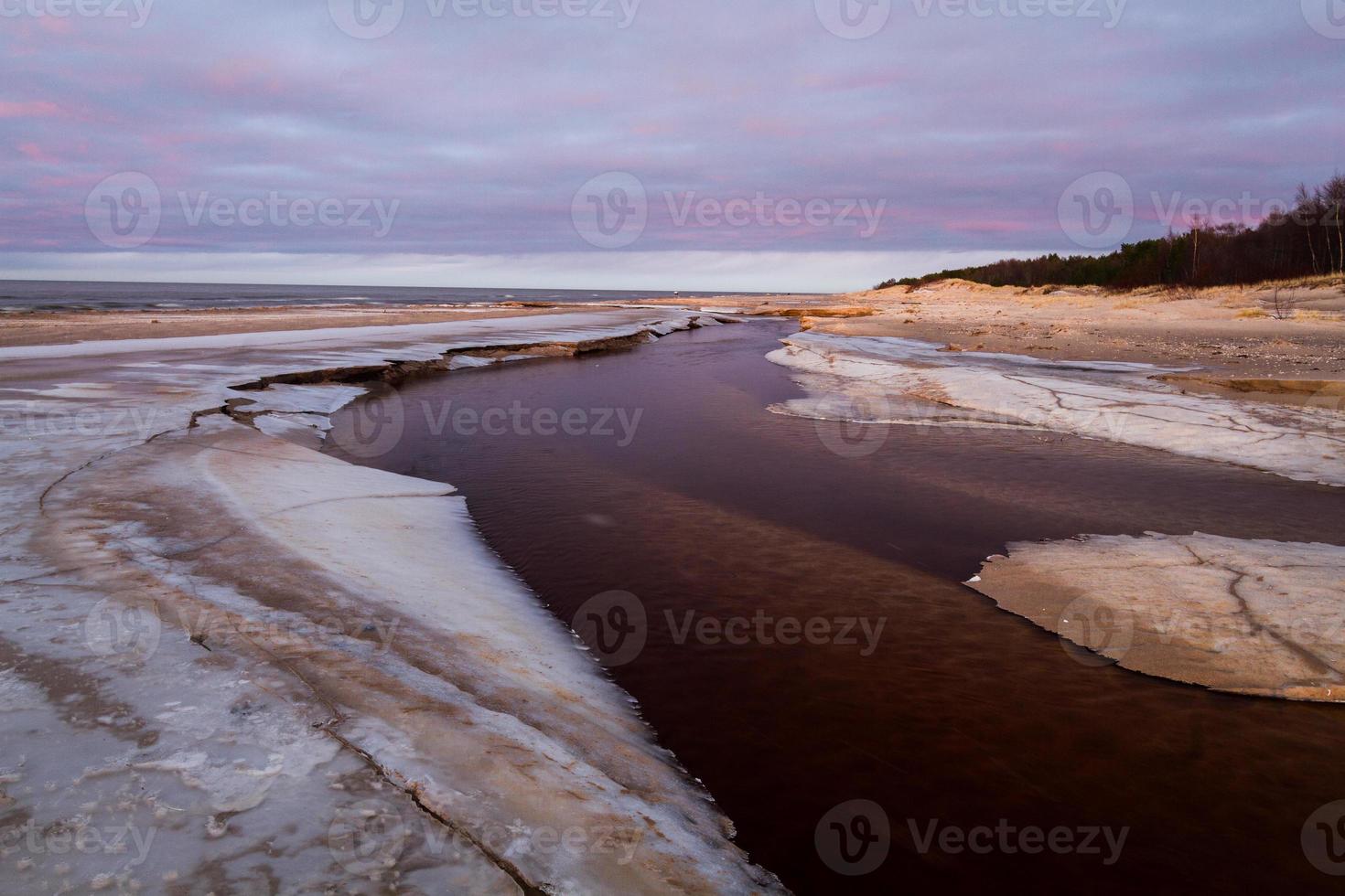 costa do mar báltico no inverno com gelo ao pôr do sol foto