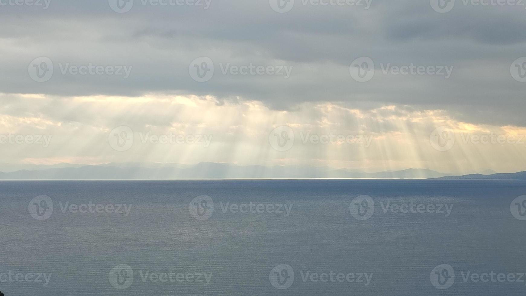 cenário do mar, com nuvens e raios solares foto