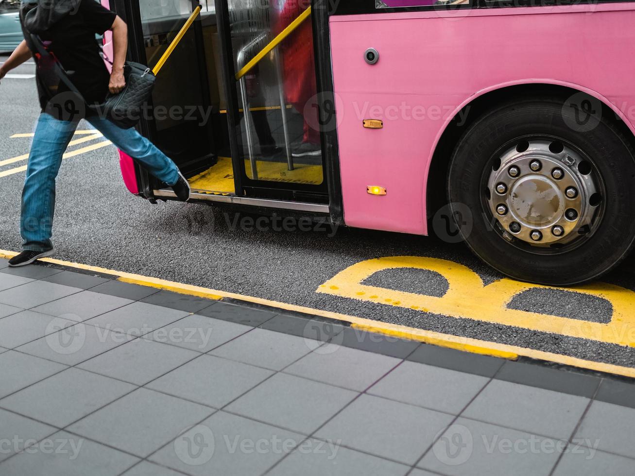 um homem pulando de um ônibus rosa foto