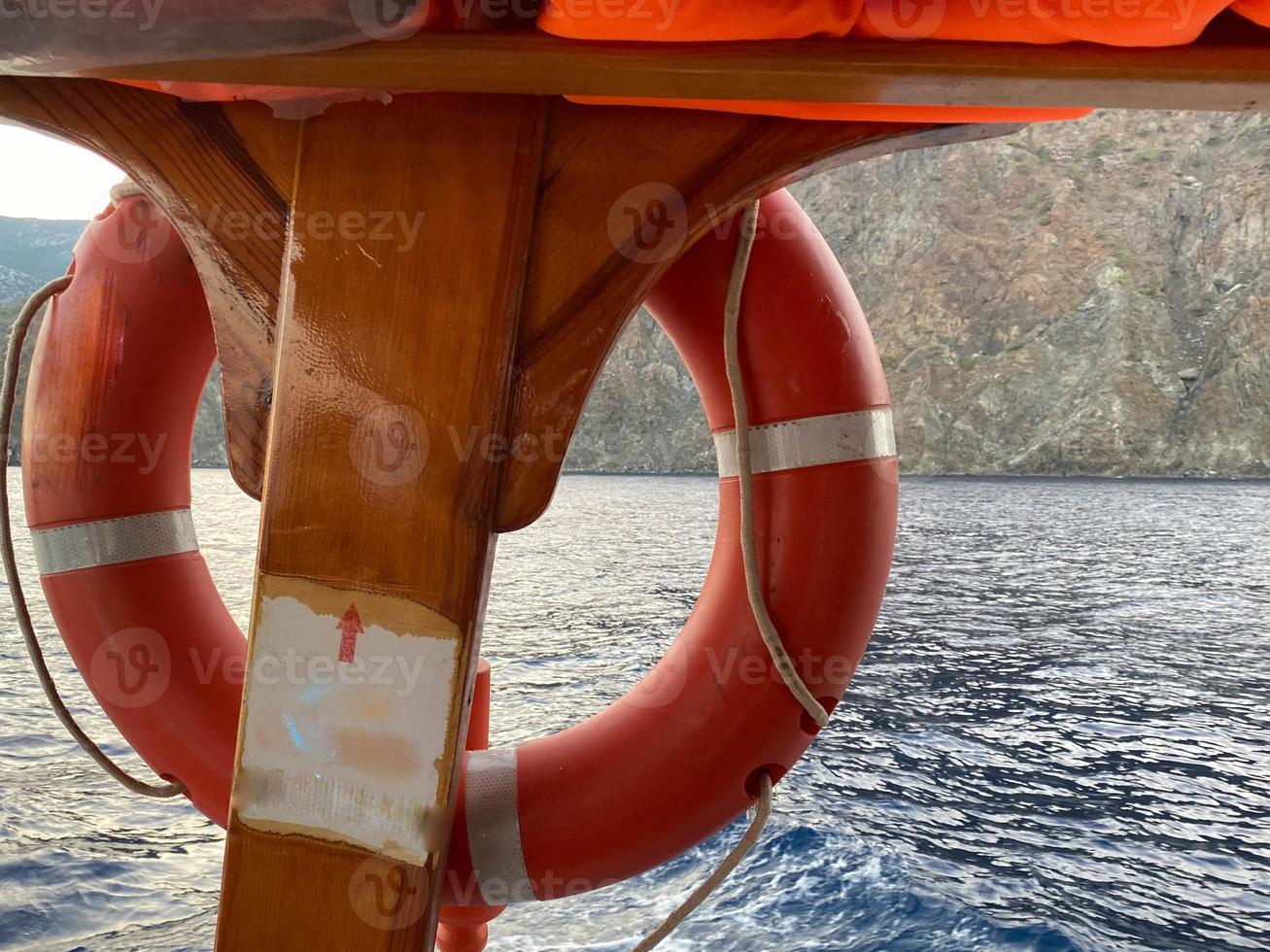 bóia salva-vidas vermelha em frente ao mar azul e ao navio branco foto