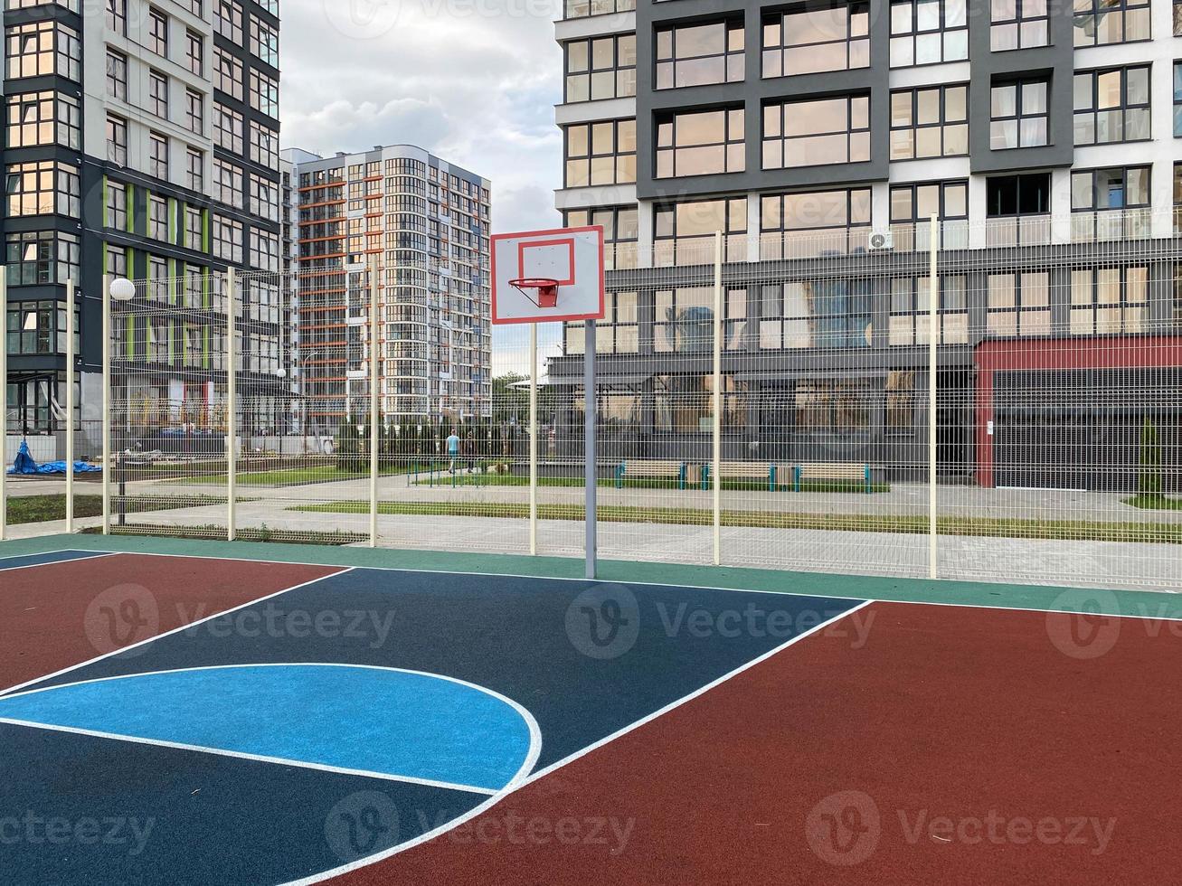 playground público multifuncional da cidade com superfície tartan no parque é usado para jogar cestas de gols de futebol de basquete foto