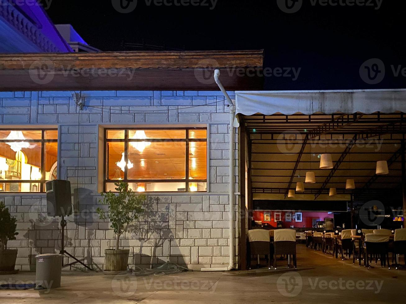 restaurante vazio de cena noturna com cadeiras e mesas na rua foto