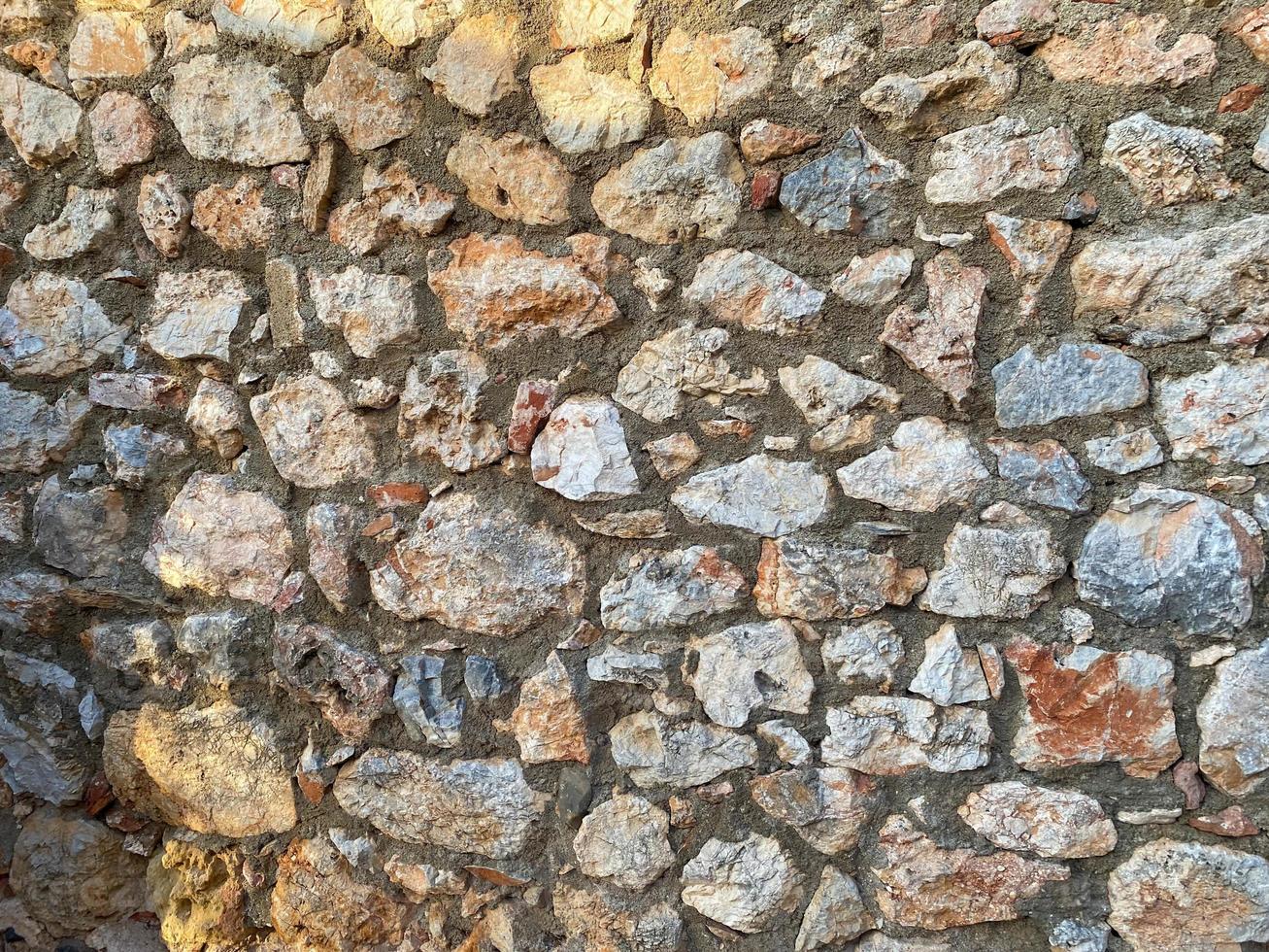 fundo, textura, parede de pedra de pedras redondas paralelepípedos tijolos superfície natural natural afiado convexo pedra áspera calçada com rachaduras foto