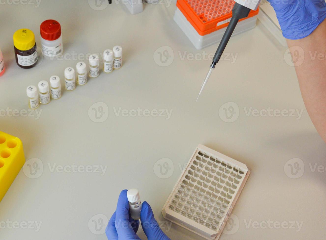 mão do cientista segurando balão com vidro de laboratório e tubos de ensaio em fundo de laboratório químico, conceito de pesquisa e desenvolvimento de laboratório de ciências foto