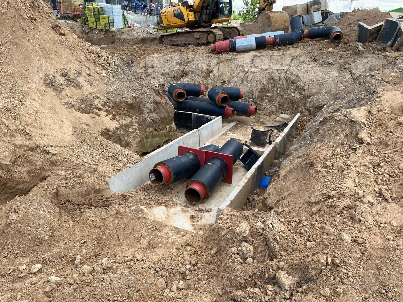 grandes tubos de água de plástico de polietileno de grande diâmetro industrial moderno encontram-se em um poço subterrâneo em um canteiro de obras durante um reparo de tubo de água foto