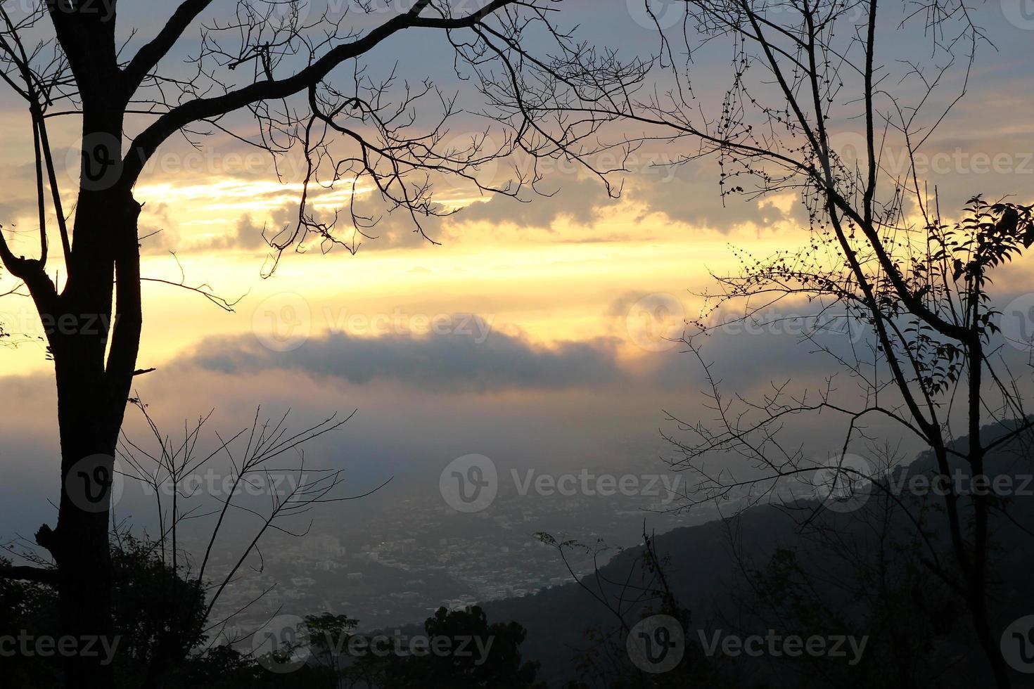 vista em uma cidade da montanha com lindo céu colorido ao nascer do sol e árvores em primeiro plano. Doi Suthep, Tailândia foto