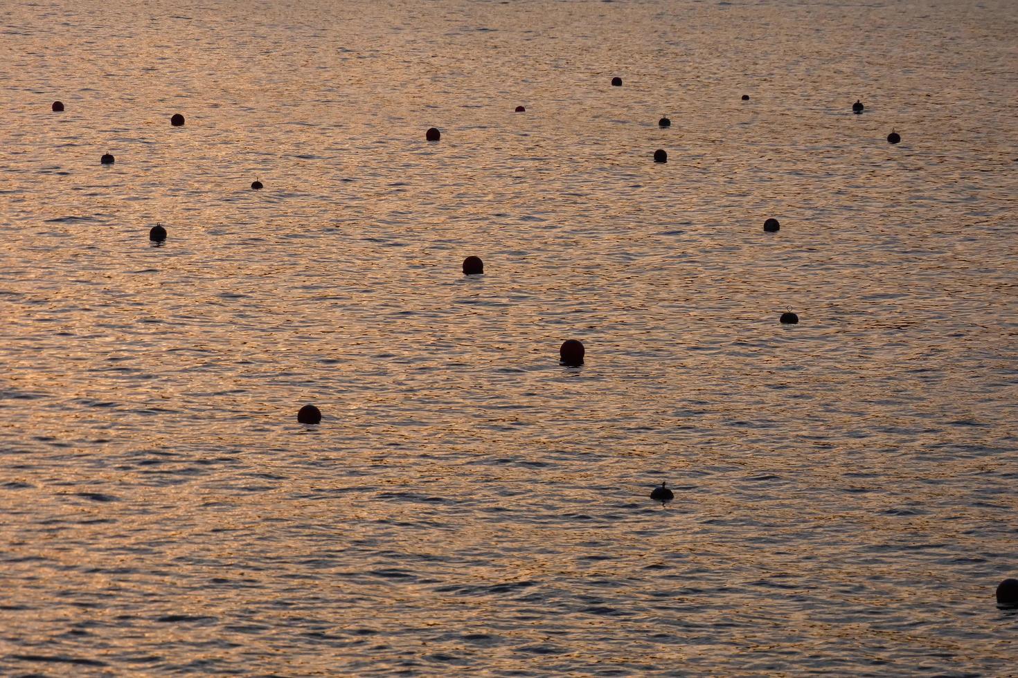 bóias de marcação para atracação de pequenos barcos na baía foto