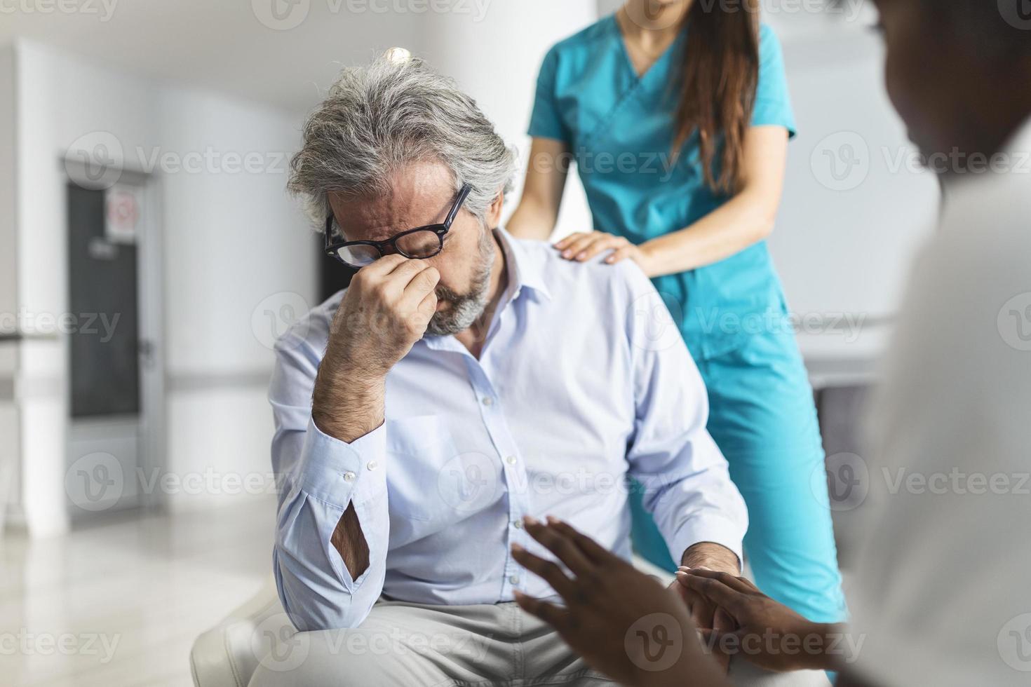 médico consolando homem chateado na sala de espera do hospital. paciente recebendo más notícias, ele está desesperado e chorando, apoio médico e confortando seu paciente com simpatia. foto