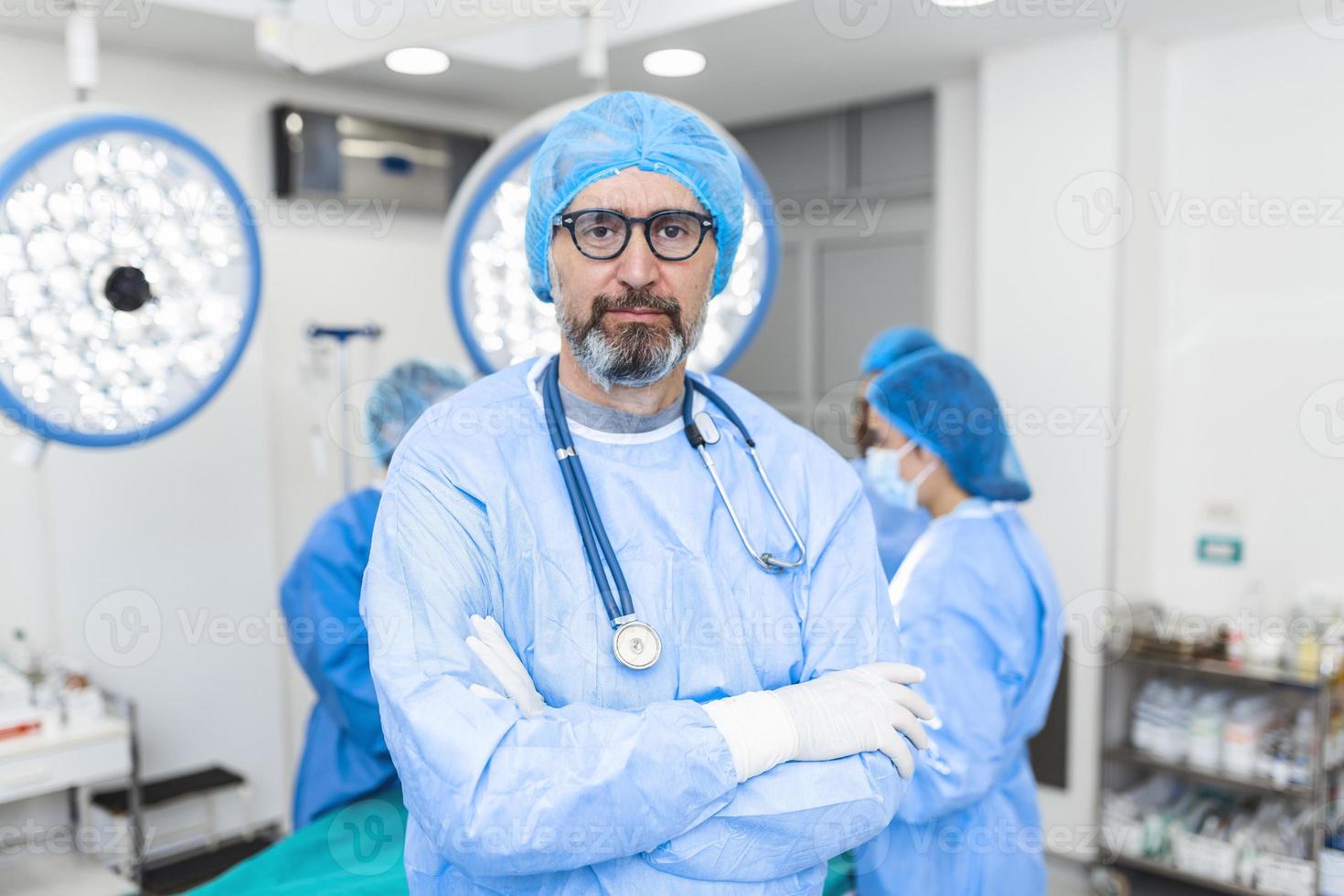 retrato do cirurgião masculino no teatro de operação, olhando para a câmera. médico em jaleco e máscara médica na sala de cirurgia do hospital moderno. foto